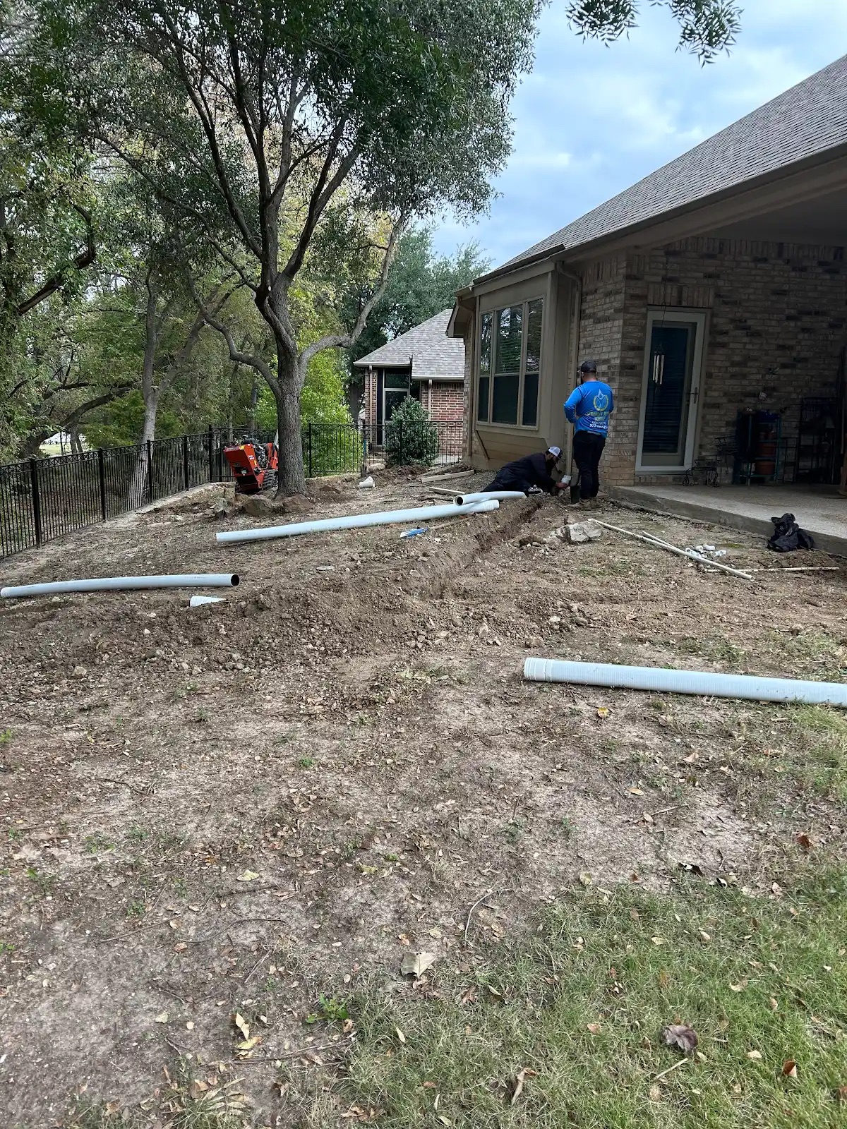 French drain trench with gravel and fabric in North Texas clay soil